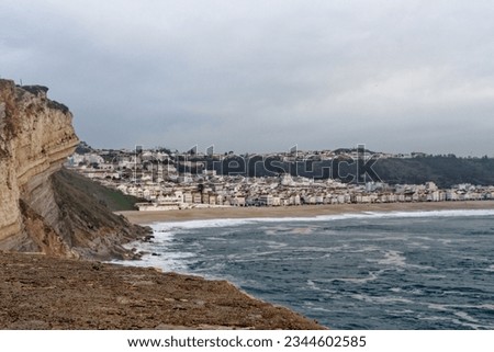 Town of Nazare, Portugal - view below the cliffs. Top view of Nazare town and sand beach. The biggest waves in the world are in Nazare, Leiria District, Portugal
