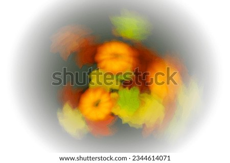 Pumpkins and colorful leaves design on a light background, intentional movement, white vignetting
