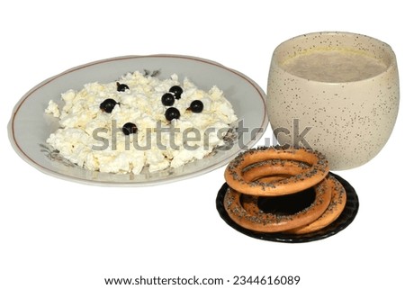 The picture shows a plate of cottage cheese, a cup of cocoa and bagels isolated on a white background.