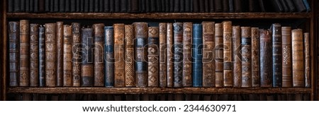 Old books on wooden shelf. Many of beautiful retro book covers, skins. Bookshelf history theme grunge background. Concept on the theme of history, nostalgia, retro.  Royalty-Free Stock Photo #2344630971