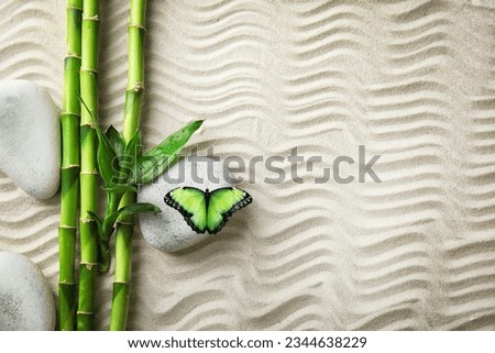 Harmony and peace. Butterfly in zen garden, bamboo branches and stones on sand with pattern, top view. Space for text