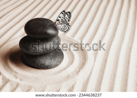 Peace and harmony. Stacked zen garden stones on sand with pattern and beautiful butterfly, space for text