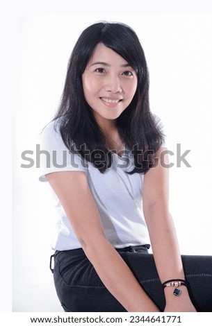 image of young woman t-shirt, jeans sitting chair over white background