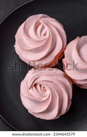 Delicious sweet colored marshmallow on a dark concrete background. Healthy sweets for the dinner table