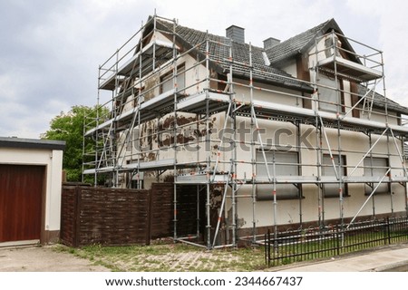 a private house in Germany, which is being prepared for painting and metal scaffolding has been installed around Royalty-Free Stock Photo #2344667437