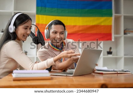 A cheerful Asian gay enjoys reading comments online while streaming live podcasts with his female colleague in the studio. broadcasting, live streaming, radio