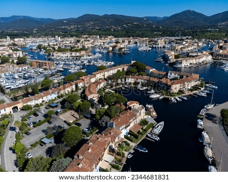 Arial view on blue water of Gulf of Saint-Tropez, boats, houses in Port Grimaud and Port Cogolin, villages on Mediterranean sea with yacht harbour, Provence, summer vacation in France.