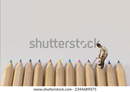 Worker with scythe on colorful crayons , light background
