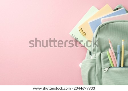 Chic girly learning essentials setup. Top view of open sage backpack with stationery, pencils, pens, lot of colorful copybooks and diary on pastel pink background with room for text or advert