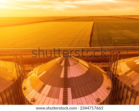 Modern metal silos on agro-processing and manufacturing plant. Aerial view of Granary elevator processing drying cleaning and storage of agricultural products, flour, cereals and grain. Nobody. Royalty-Free Stock Photo #2344717663