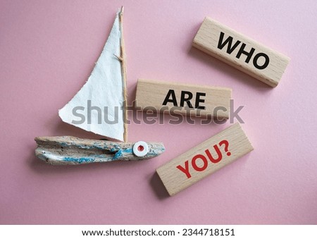 Who are You symbol. Concept words Who are You on wooden blocks. Beautiful pink background with boat. Business and Who are You concept. Copy space. Concept word