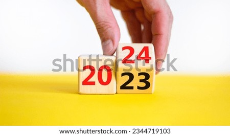 Business concept of 2024 new year symbol. Businessman turns a wooden cube and changes number 2023 to 2024. Businessman hand. Beautiful white background, copy space. 2024 happy new year concept.