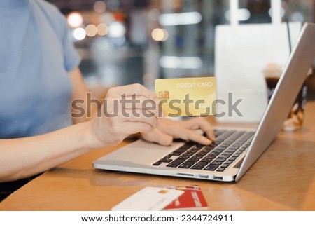 Woman's  holding a credit card and using laptop for online shopping