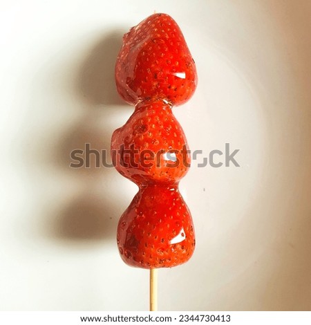 Tanghulu Strawberry candied coated in clear and crispy sugar glaze, Tang dun er coated in a hardened sugar syrup Royalty-Free Stock Photo #2344730413