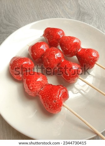Tanghulu Strawberry candied coated in clear and crispy sugar glaze, Tang dun er coated in a hardened sugar syrup Royalty-Free Stock Photo #2344730415