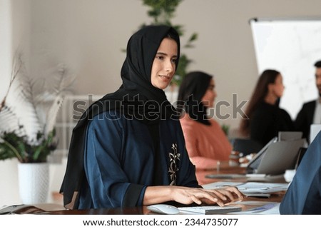 Woman in Hijab Abaya at indoor place ideal for corporate office or University campus concept. Saudi Arabia, UAE, Oman, Kuwait, Qatar, Bahrain education concept Royalty-Free Stock Photo #2344735077