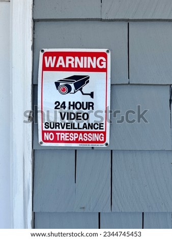 A sign that says "Warning 24 Hours Video Surveillance No Trespassing".