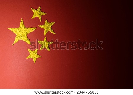 Chinese flag with yellow stars made of rice on a red background.