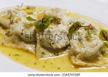 Italian food, mushroom stuffed ravioli pasta with creamy parmesan cheese sauce in a white plate Royalty-Free Stock Photo #2344769289