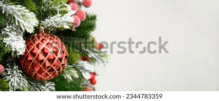 Christmas winter banner with red balls and fir branches on white background. Xmas greeting card. Holiday time. Happy New Year. Space for text. Close up.