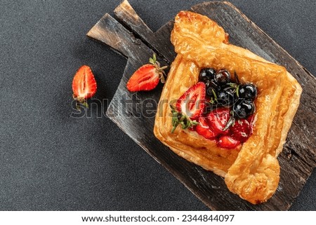 square fruit filled French puff pastry dessert with berries on a dark background. banner, menu, recipe place for text, top view. Royalty-Free Stock Photo #2344844097