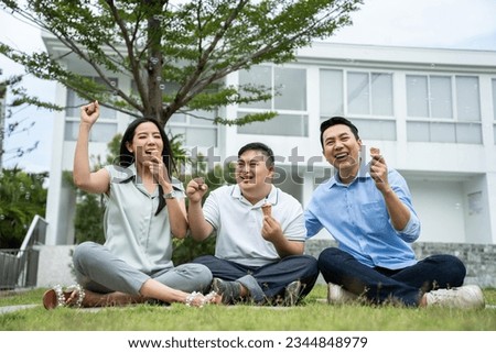 Asian attractive family, parents playing with young son in the garden. Beautiful loving couple, father and mother support take care young happy man special needs person outdoors in backyard at home. Royalty-Free Stock Photo #2344848979