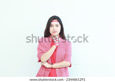 portrait of an asian woman wearing a red outfit celebrating Indonesia's independence day while smiling expression isolated on white background. soft focus