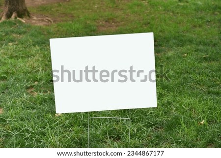 Empty white sign suitable for mock up in a yard of grass lawn. 
