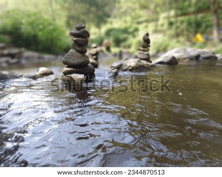
stones piled on top of flowing river water, it's amazing Royalty-Free Stock Photo #2344870513