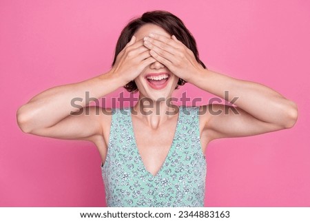 Photo of young funny excited playful positive woman cover hands eyes secret surprise game hide seek isolated on pink color background