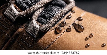 waterproof leather shoes. closeup of rain drops on water resistant footwear. weatherproof clothing Royalty-Free Stock Photo #2344883789