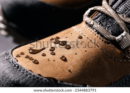 waterproof leather boots. closeup of rain drops on water resistant footwear. weatherproof clothing Royalty-Free Stock Photo #2344883791