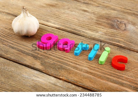 Garlic word formed with colorful letters on wooden background