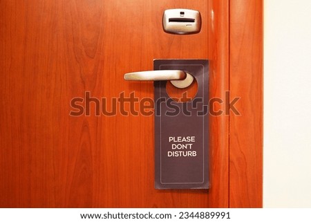 Do Not Disturb door hanger hanging on hotel room door handle