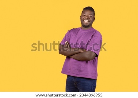 Cheerful African American Guy Posing Crossing Hands Laughing And Expressing Positive Emotions, Standing With Confidence Over Yellow Background. Studio Shot Of Happy Self Confident Black Man Royalty-Free Stock Photo #2344896955