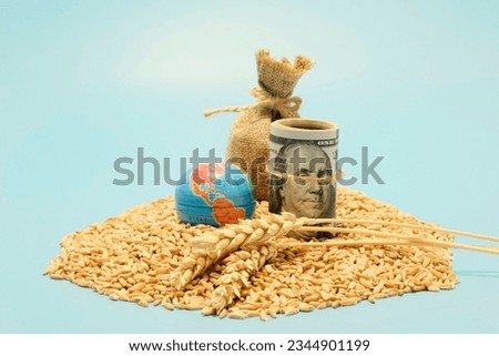Grain deal, yield concept. American dollars, a small globe next to a scattered grain of wheat. The economic crisis during the hostilities. The threat of hunger.