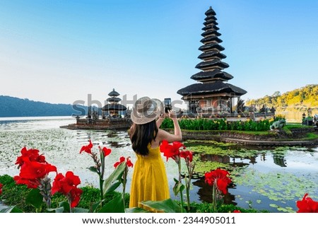 Young woman tourist relaxing and enjoying the beautiful view at Ulun Danu Beratan temple in Bali, Indonesia Royalty-Free Stock Photo #2344905011