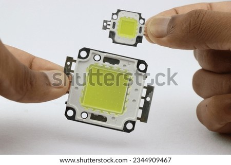 High power light emitting diode chips of various size held in the hand. smd led bead chips Royalty-Free Stock Photo #2344909467