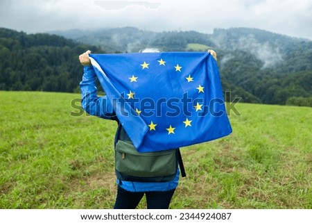 Woman with waving european union flag on a mountain background.. High quality photo