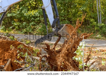 Land clearing for housing complex skid steer tractor removes roots efficiently Royalty-Free Stock Photo #2344947167