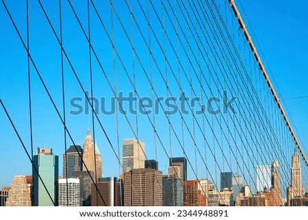 Skyline of buildings at Wall Street and Downtown Manhattan behind the cables of Brooklyn Bridge, Manhattan, New York City, NY, USA