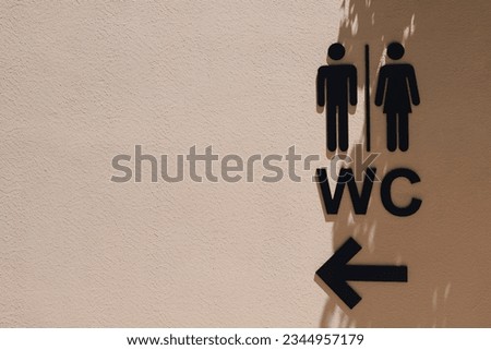 Black male and female public restroom sign with right direction on the wall with shadows.Toilets man and woman icon. WC sign icon.