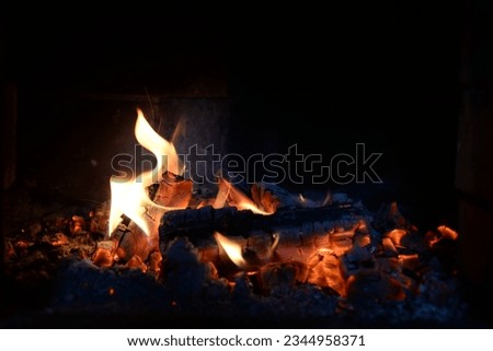 Smoldering coals, fire and sparks in a fireplace on a black background
