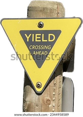 Isolated Yield sign mounted on a wooden post at a hiking trail