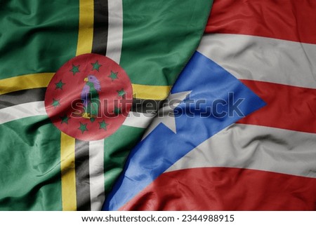 big waving realistic national colorful flag of dominica and national flag of puerto rico . macro