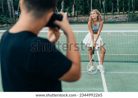 the photographer photographs a blonde model girl on a green tenn