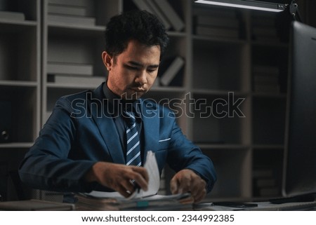 The male employee is in the office in the middle of the night, he works overtime at a startup company, he is working hard and overtime. Overtime concept. Employees of private companies.