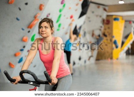 Sports girl on an exercise bike in a climbing hall