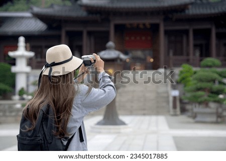 Asian tourist, cute woman with long hair are traveling in Hong Kong along with map and her camera with fun on her holiday, A temple in Hong Kong, concept travel, Nan Lian garden, Chinese classical. 