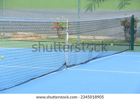 Athlete competes on court with net at sports venue.